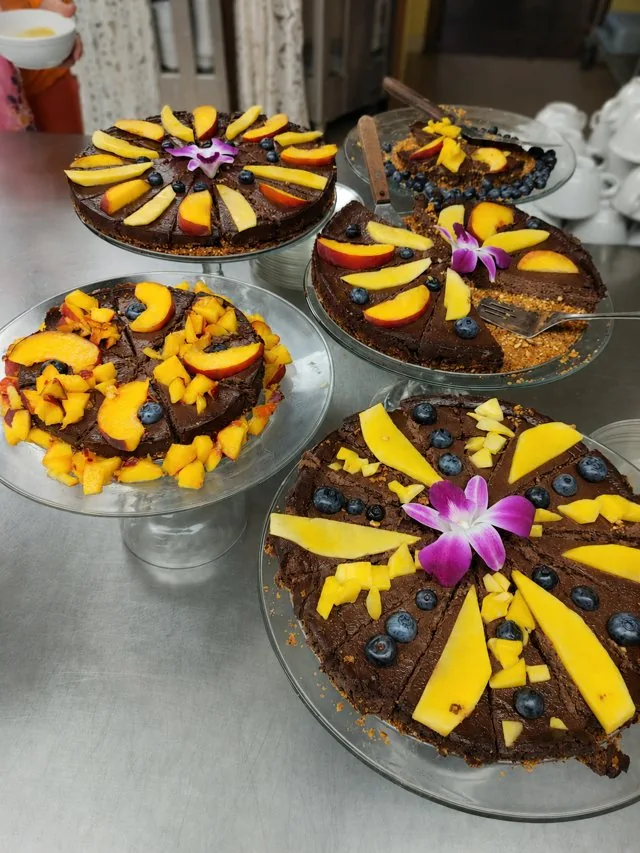 Chocolate tortes topped with mango, peach and edible flowers